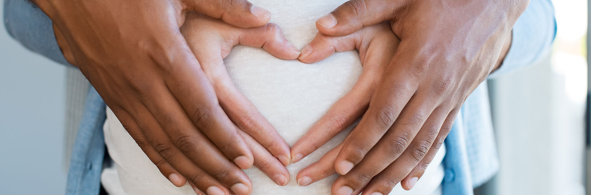 pregnant belly with hands in shape of a heart